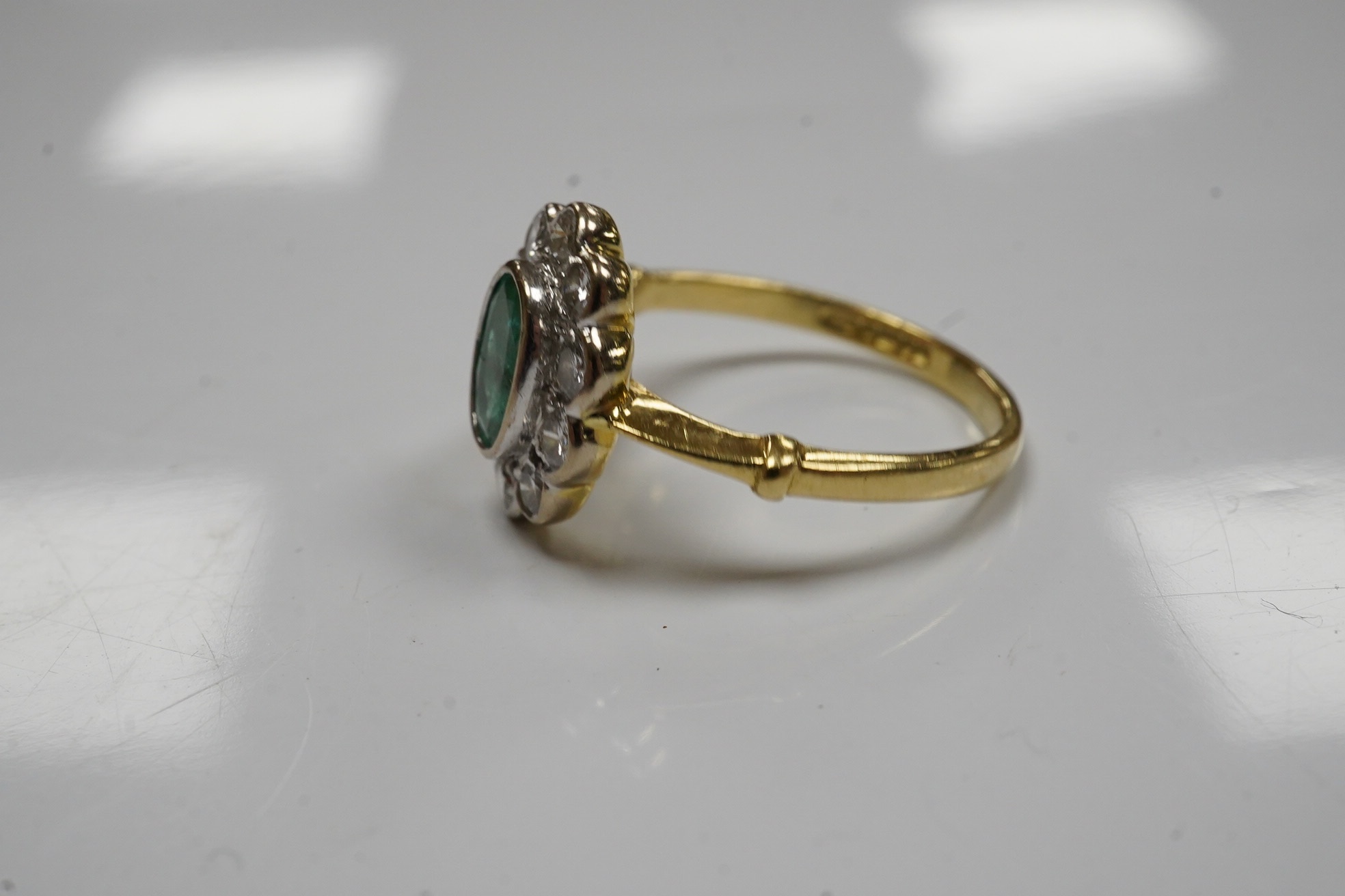 A modern 18ct gold, emerald and diamond set oval cluster ring, size L, gross weight 3.5 grams. Condition - poor to fair